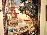 a tapestry on the wall of a room with a painting on it