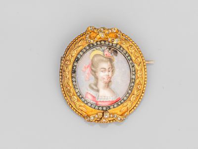 un gros plan sur une broche en or représentant le portrait d'une femme