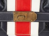 a close up of a red, white and blue bag with a gold buckle