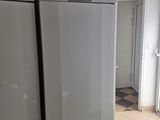 a white refrigerator in a kitchen with tile flooring