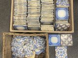 two baskets filled with blue and white tiles sitting on top of a carpet