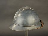a silver helmet on a metal stand on a gray background