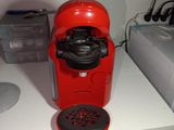a red coffee maker sitting on a white counter