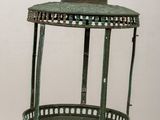an old green lantern on a wooden table with a white wall in the background