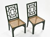 pair of black chairs with wicker seats on a white background