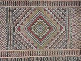 an old rug with a diamond design on it