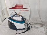 a black and blue steam iron sitting on a white table