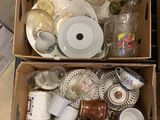 two boxes full of dishes and cups sitting on the floor