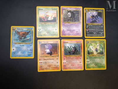 several pokemon cards sitting on a table with a black background