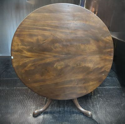 une petite table ronde avec un plateau en bois posé sur un piètement en métal