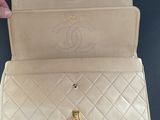 a person holding a white purse with a chain around it