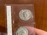 a person holding two silver coins in their hand