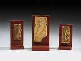 trois plaques en bois ornées de reliefs représentant une femme et un homme