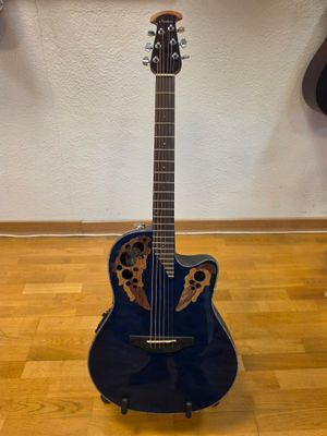 an acoustic guitar sitting on top of a hard wood floor