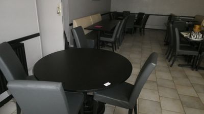 tables and chairs in a restaurant with a black table and black chairs