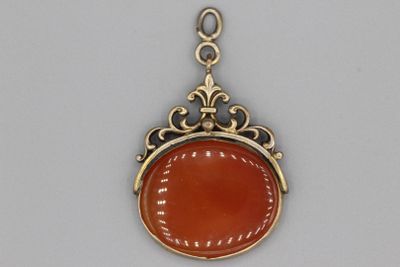 une image représentant un pendentif en or et en cornaline monté sur une chaîne