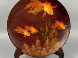 a decorative plate with gold fish painted on it