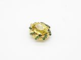 a close up of a yellow and green ring on a white surface