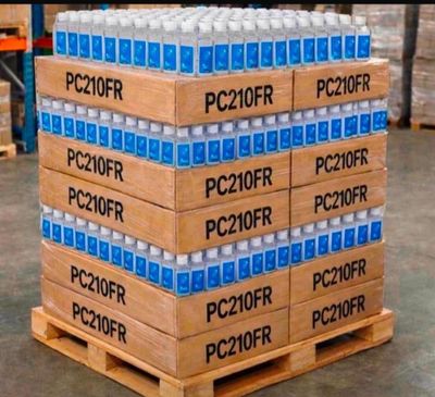 Des cartons d'eau sont empilés sur une palette dans un entrepôt