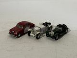 three toy cars sitting next to each other on a white surface