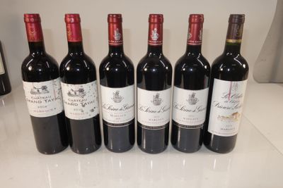 six bottles of red wine lined up on a counter top