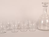 many glasses and a decanter sitting on a table