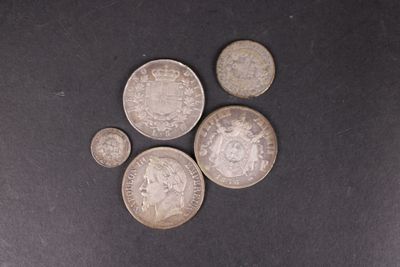 six types différents de pièces d'argent sur une surface noire