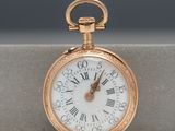 a gold pocket watch with roman numerals on it