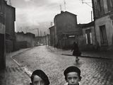 black and white photograph of two boys standing on a cobblestone street