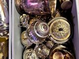 deux bacs remplis d'objets en argent posés sur une table