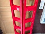 a red shelf that is on the floor in front of a door