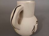 a white vase with a black design on it