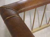 a close up of a brown leather chair with a metal frame