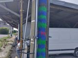 a white van parked in front of a building with a blue and green spray painted on it