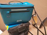 a blue cooler sitting on top of a table next to a black chair