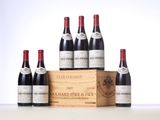 six bottles of red wine in a wooden box on a table