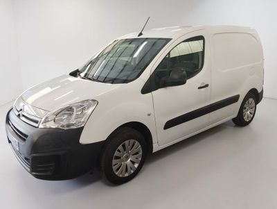 La camionnette blanche est garée dans une pièce blanche au sol blanc.