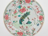 une image représentant une assiette ornée d'un paon et de fleurs