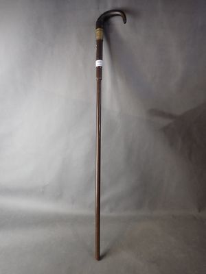 une vieille canne avec un manche en bois sur fond blanc