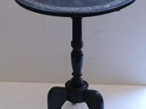 a small black table with a flower design on it