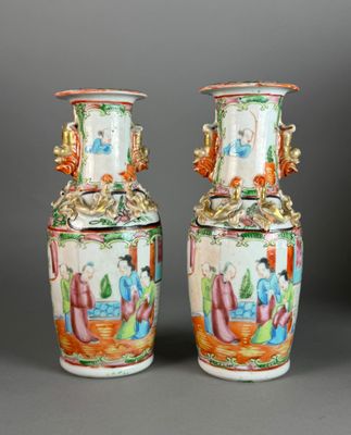 pair of chinese vases with figures on them on a grey background