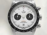 a close up of a watch with a white face and black bezel