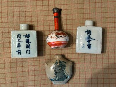 trois petits vases et une bouteille posés sur une table