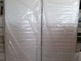 a large stack of white mattresses in a room