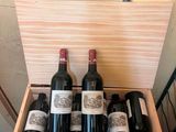 several bottles of wine are in a wooden box on a table
