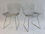 pair of chrome wire chairs against a white backdrop with a white backdrop