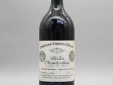 une bouteille de vin rouge posée sur une table blanche