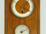 une image représentant une horloge en bois équipée d'un thermomètre et d'un baromètre