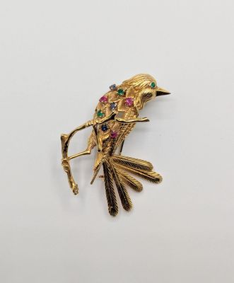 an image of a gold bird broochle on a white background