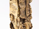 a gold statue of a man and a woman holding a book